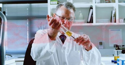 Senior scientist conducting laboratory experiment with precision