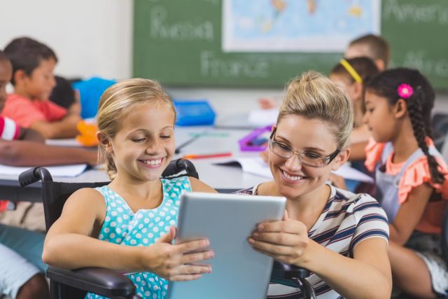 Schoolgirl and teacher using digital tablet in classroom - Download Free Stock Photos Pikwizard.com