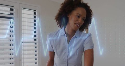 Nurse Assisting Senior Woman Home Exercise with Digital Heart Monitor