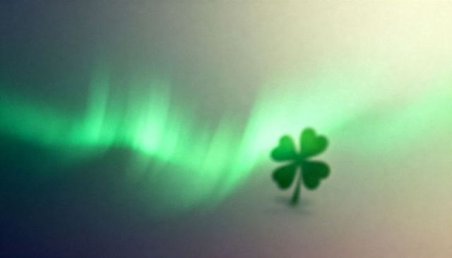 Glowing four-leaf clover beneath northern lights on misty teal night