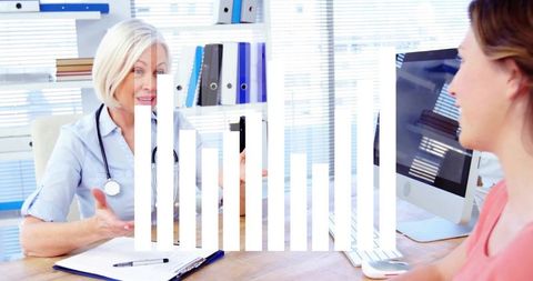 Doctor gesturing during patient consultation in bright clinic with clipboard and computer