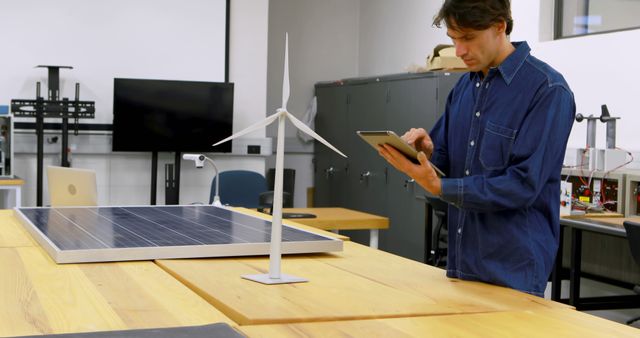 Young Caucasian man examines renewable energy models in a lab, with copy space - Download Free Stock Photos Pikwizard.com