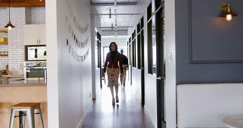 Portrait of Business Professionals Walking Confidently in Office Corridor