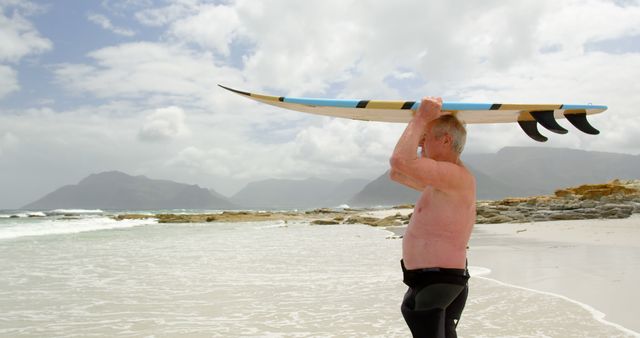 Senior Man Ready to Surf on Coastal Beach - Download Free Stock Images Pikwizard.com