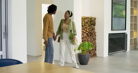 Young African American Couple Holding Hands Entering Modern Minimalist Home Interior