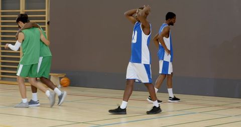 Teammates helping injured player stand after bench support showing resilience, teamwork