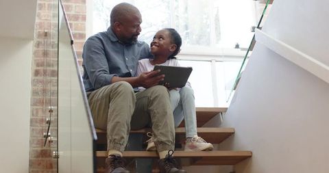 Father and Daughter Bonding with Digital Tablet on Stairs