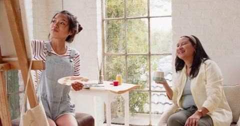 Mother and Daughter Creating Art in Sunlit Studio