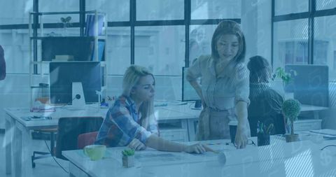 Women Collaborating on Creative Project in Modern Office