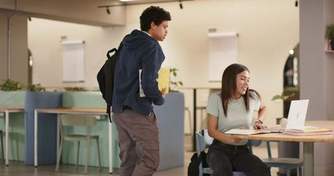 African american students studying together in campus lounge with laptop and notebooks