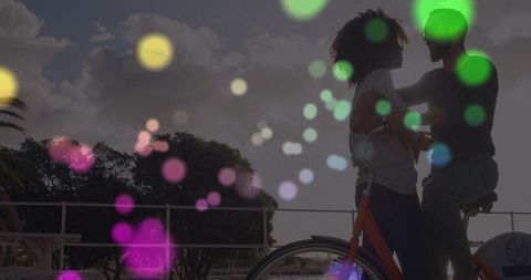 Romantic Couple Embracing with Bicycle on Scenic Waterfront at Sunset
