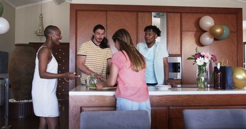 Group of Friends Cooking and Chatting in Modern Kitchen Setting
