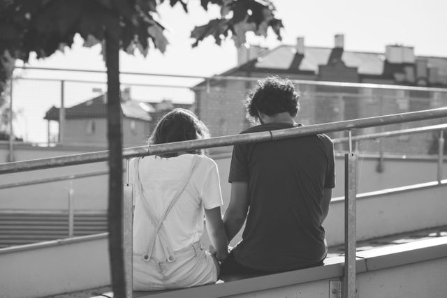 Grayscale Photo of Man and Woman Sitting on Inclined Road - Download Free Stock Photos Pikwizard.com