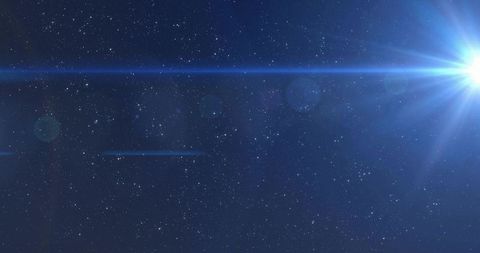 Blue stellar flare emitting radial beams across starfield with lens flares and halo