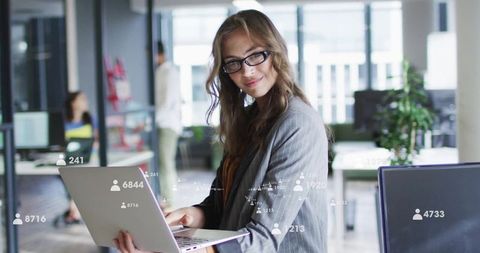 Businesswoman Analyzing Data Insights on Laptop in Modern Office