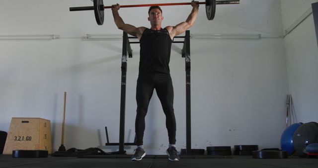 Man lifting barbell doing shoulder press in a gym. Showcasing determination and strong physique. Can be used for fitness advertisements, workout routines, strength training programs, or motivational fitness content.