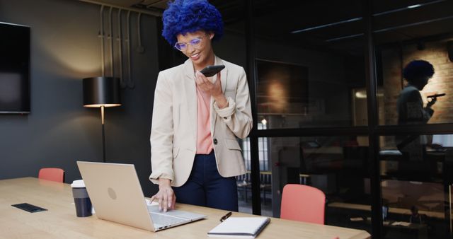 Businesswoman with Blue Hair Using Smartphone and Laptop in Modern Office - Download Free Stock Images Pikwizard.com