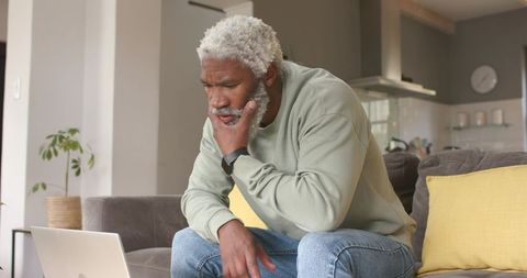 Focused Mature Man Using Laptop in Cozy Living Room