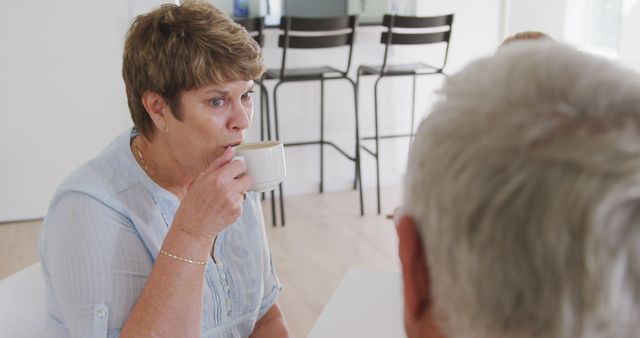 Elderly Woman Drinking Coffee While Conversing at Home - Download Free Stock Images Pikwizard.com