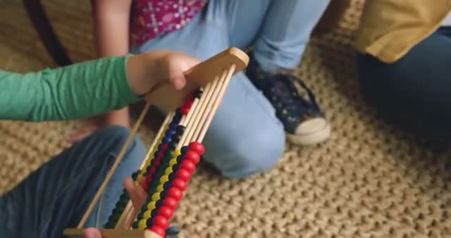 Child using a colorful wooden abacus for learning mathematics at home, highlighting hands-on education and early childhood development. Ideal as an educational visual for websites, blogs, and materials focusing on interactive learning or homeschooling resources.