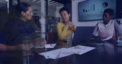 Team collaborating over sales data in modern boardroom with laptop and charts