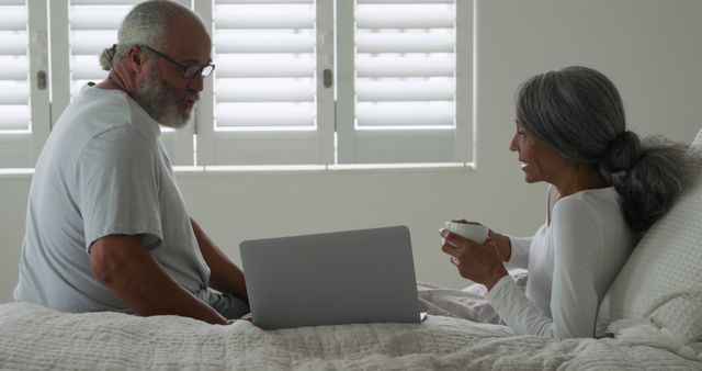 Senior Couple Relaxing in Bedroom with Laptop - Download Free Stock Images Pikwizard.com