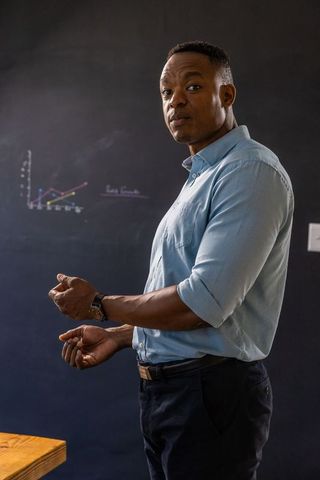 Educator Presenting on Chalkboard Wall with Graph