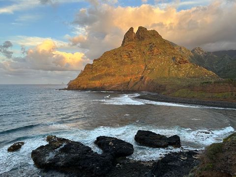 Dramatic coastal beach landscape with cliffs and waves at sunset