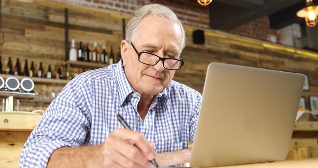 Senior man working on laptop in cozy café - Download Free Stock Images Pikwizard.com