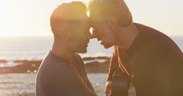 Mature couple enjoying a tender moment at the seaside during sunset, symbolizing romance and intimacy. The image can be used for marketing materials related to love, relationships, and romantic holidays. Perfect for use in advertisements, social media, and blog posts about mature relationships and lifestyle.