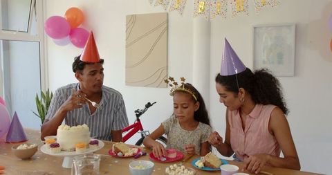Family Enjoying Birthday Celebration at Home with Cake and Decorations