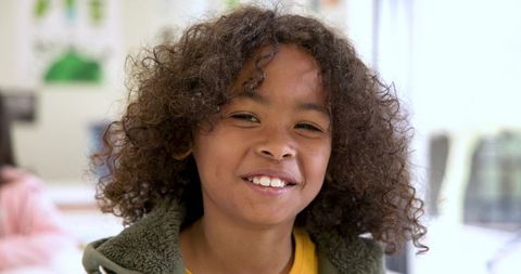 Cheerful school-age boy smiling in classroom environment