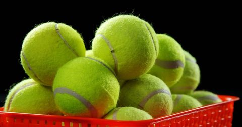 basket of tennis balls on black background - Download Free Stock Images Pikwizard.com