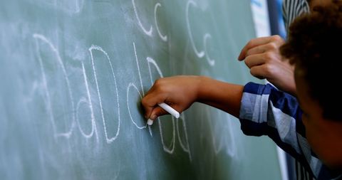 Close-Up of Teacher Guiding Student Writing Alphabet on Chalkboard - Download Free Stock Images Pikwizard.com