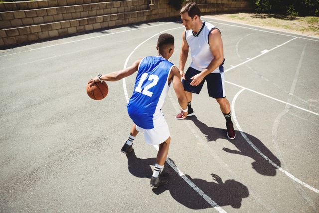 High Angle View of Two Basketball Players in Action on Outdoor Court - Download Free Stock Photos Pikwizard.com