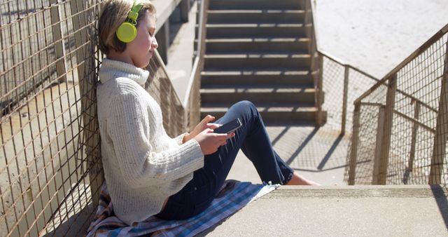 Teen Relaxing on Outdoor Steps with Headphones - Download Free Stock Images Pikwizard.com