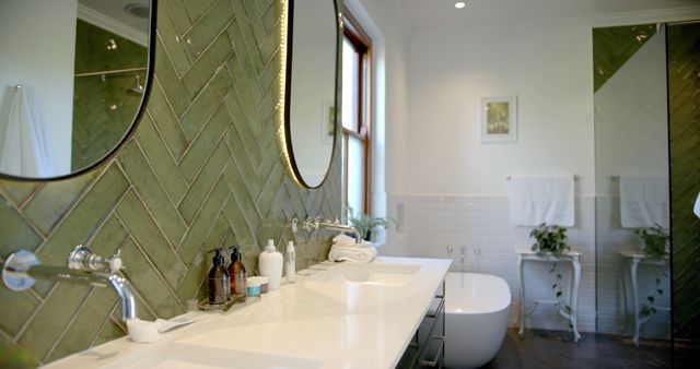 Beautiful mirrors, taps, sinks and green walls in sunny bathroom. Interior design, home and domestic life.