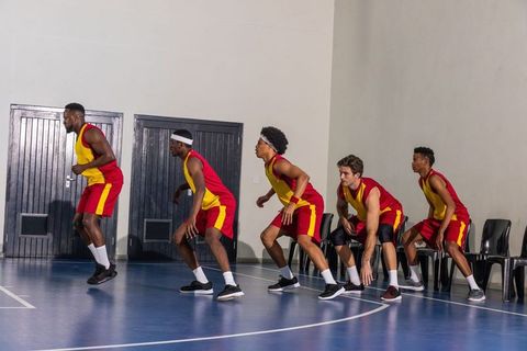 Diverse Basketball Team Defending on Indoor Court