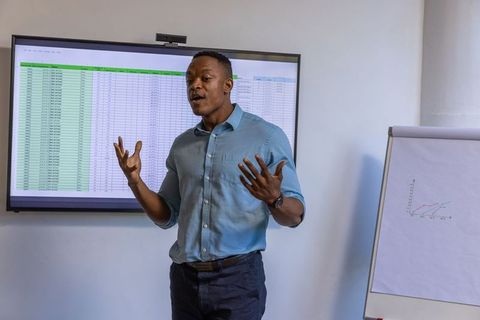 Confident Business Professional Leading Presentation in Office