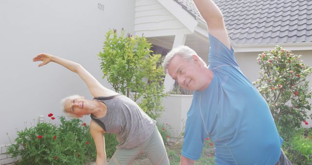 Relaxed caucasian senior couple practicing yoga in front of house. active and healthy retirement lifestyle at home and garden.