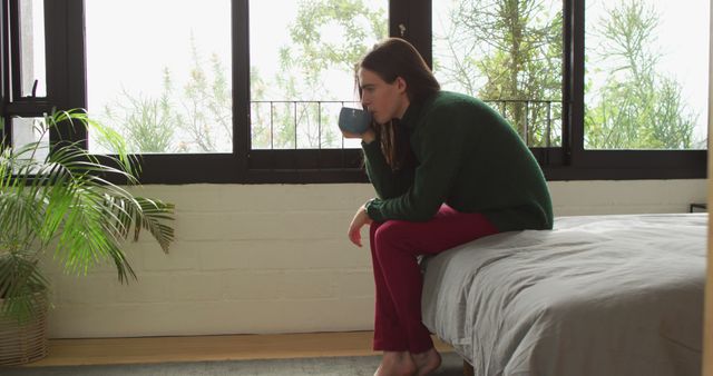 Thoughtful Woman Drinking Coffee in Modern Minimalistic Bedroom - Download Free Stock Images Pikwizard.com