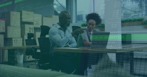 Coworkers Reviewing Encrypted Data on Laptop with Code Overlay