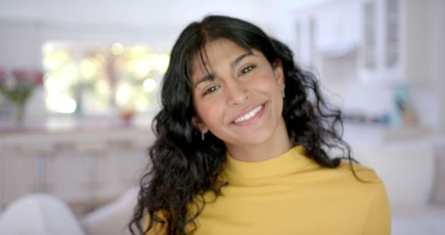 Smiling Young Woman with Curly Hair in Yellow Sweater in Kitchen - Download Free Stock Images Pikwizard.com