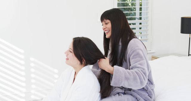 Two Women Enjoying Relaxing Hair Braiding Session in Bedroom - Download Free Stock Images Pikwizard.com