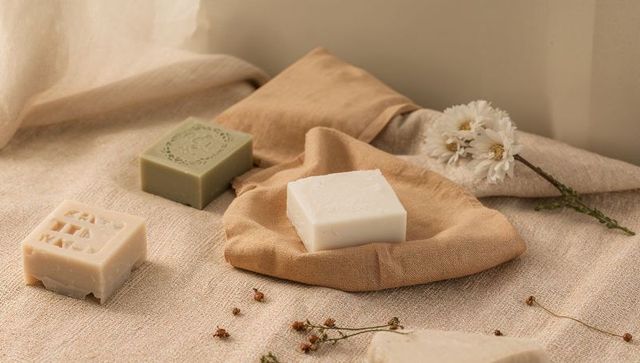 Handmade natural soap bars on neutral linen with dried flowers, cotton pouch and embossed bars