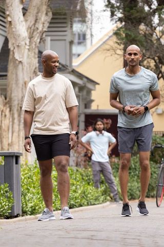 African american men walking together in urban courtyard wearing athletic apparel