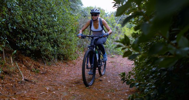 Woman mountain biking on forest trail in protective gear - Download Free Stock Images Pikwizard.com