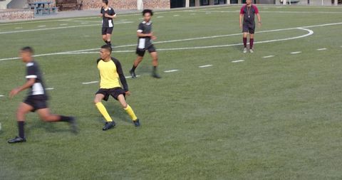 Youth soccer players engaged in competitive match on field