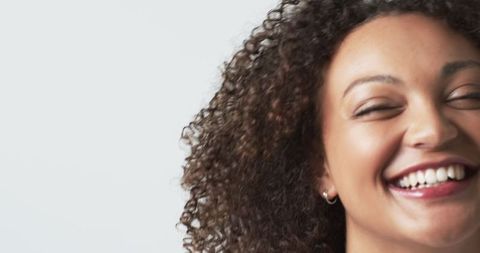 Joyful Plus Size Woman Smiling with Curly Hair Against White Background