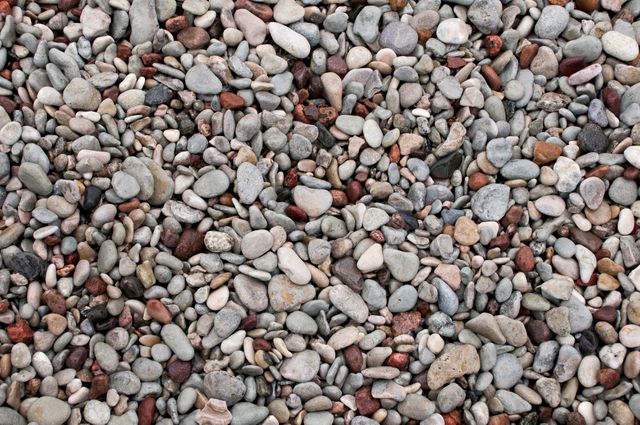 Colorful pebbles creating a vibrant texture ideal for backgrounds, wallpapers, or nature-themed projects. This versatile image can be used in designs for websites, brochures, or presentations requiring a natural, earthy feel.